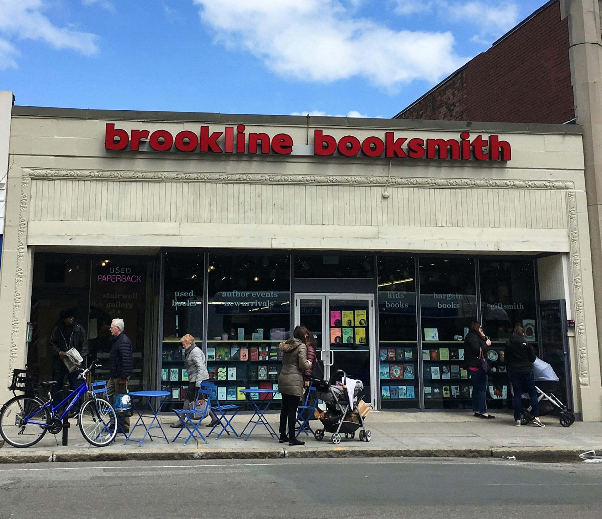 facade of bookstore in strip mall with pedestrians walking past