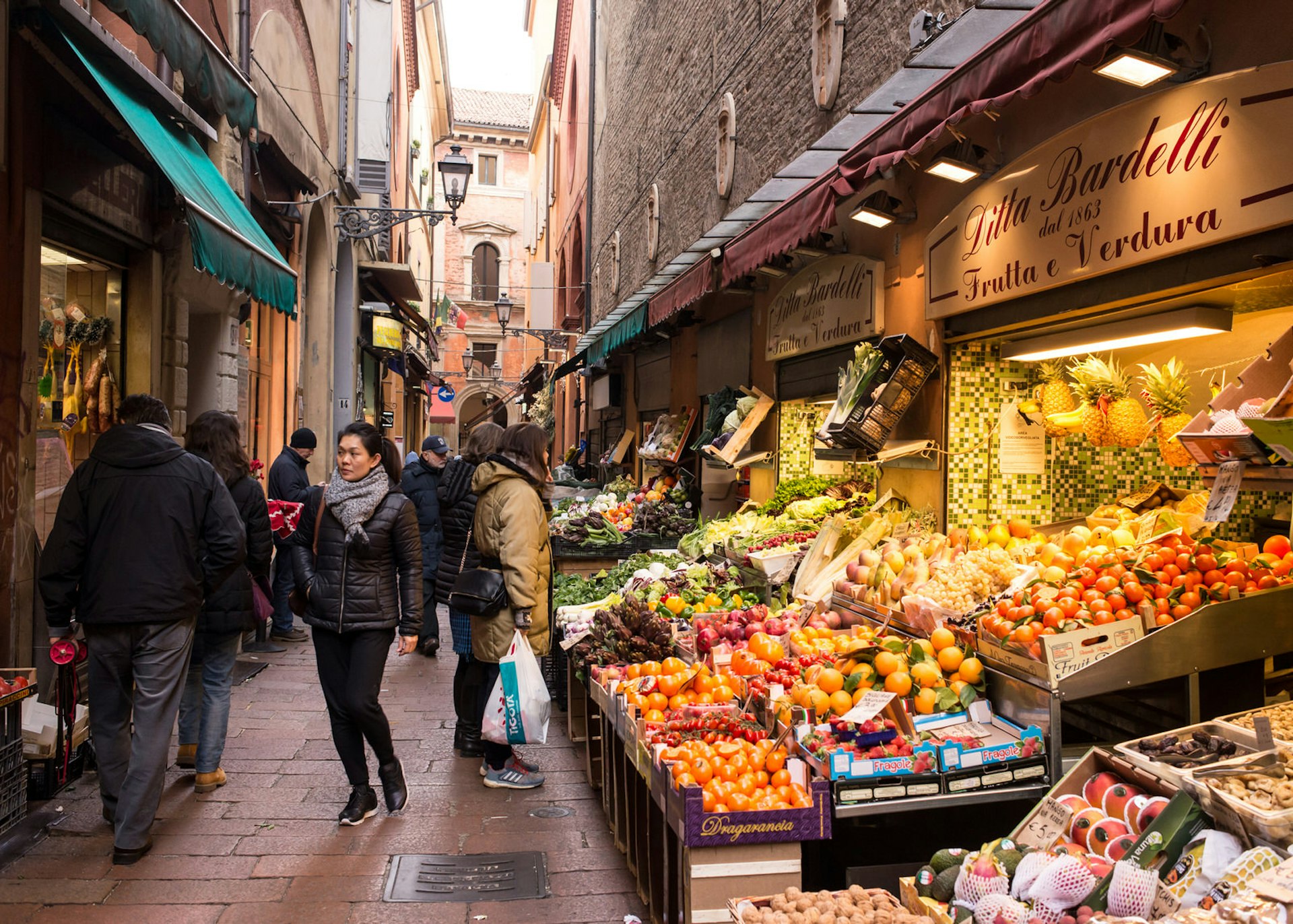 Traditional stores and food stalls in the Via Pescherie Vecchie, a famous alley in the medieval heart of Bologna, Emilia-Romagna © DrimaFilm / Shutterstock