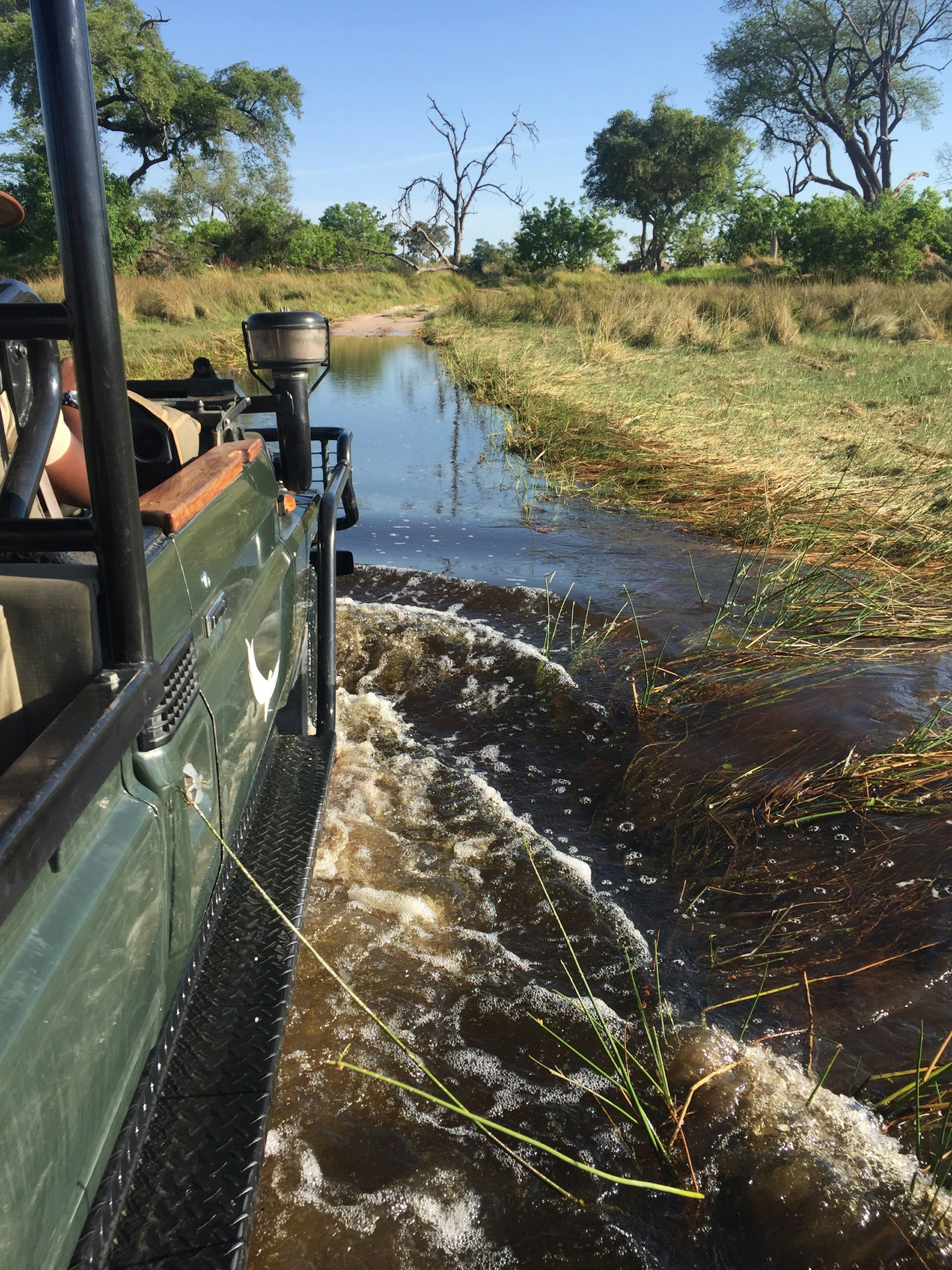 An open-sided 4WD vehicle heads through deep water © Matt Phillips / Lonely Planet