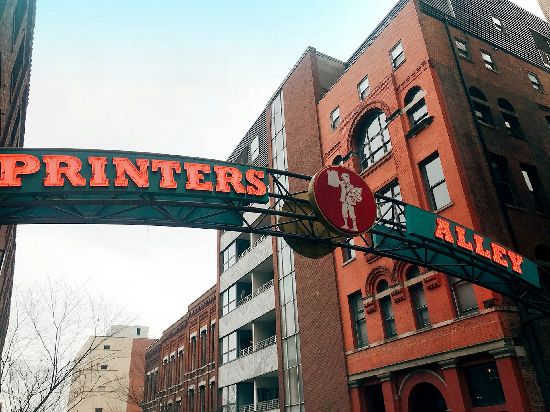 Arched neon sign reading Printer's Alley. For a music-filled trip to downtown Nashville, Printers Alley is a must. 
