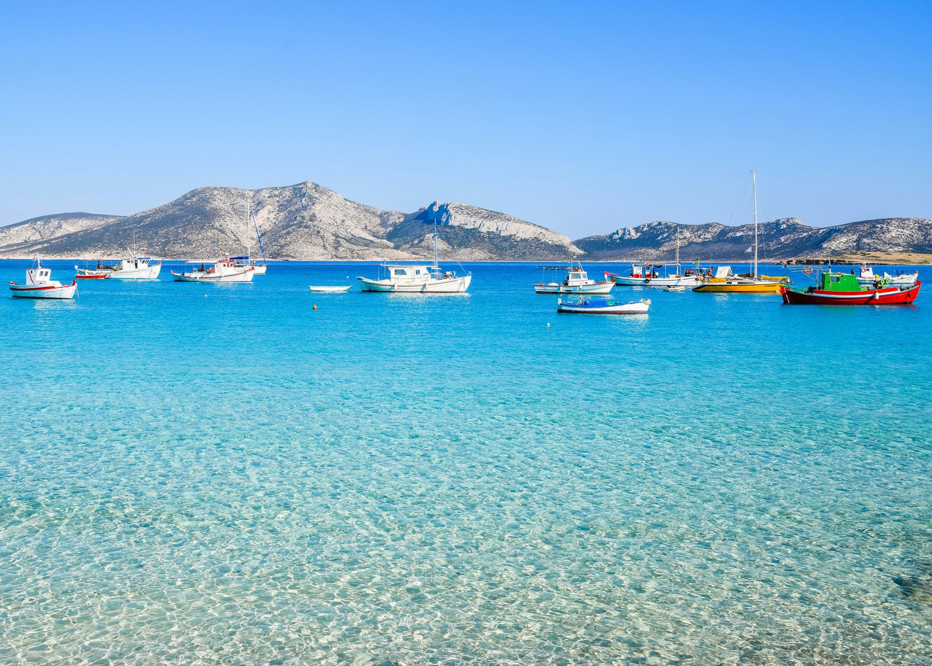Traditional fishing boats bob in the shallows of Koufonisia, the best-known of the Small Cyclades © Nicole Kwiatkowski / Shutterstock