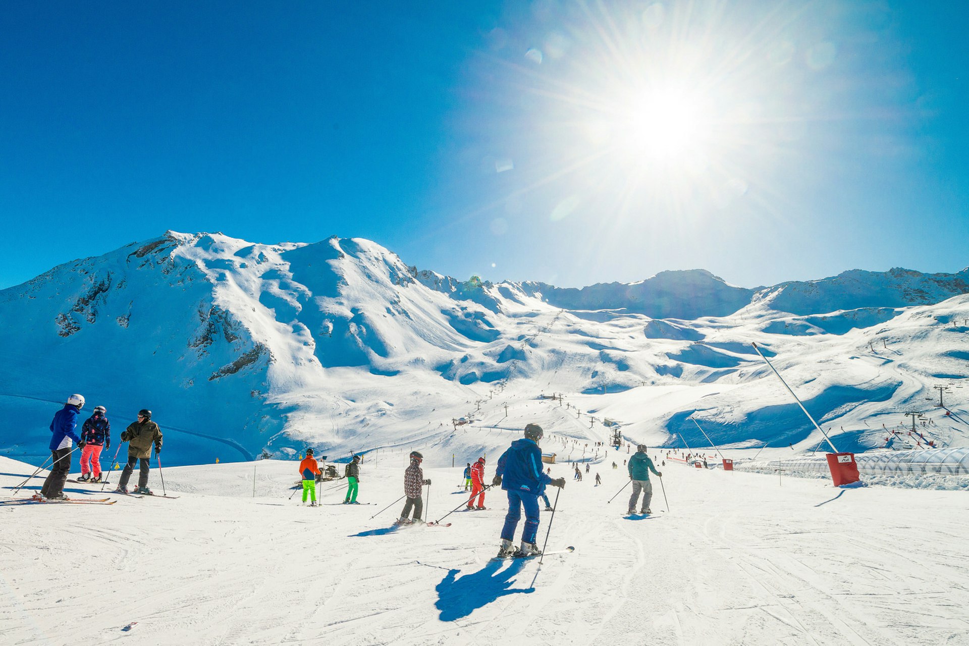 Skiers on a gentle slope surrounded by snowy mountain peaks at Val d'Isère © Val d'Isère