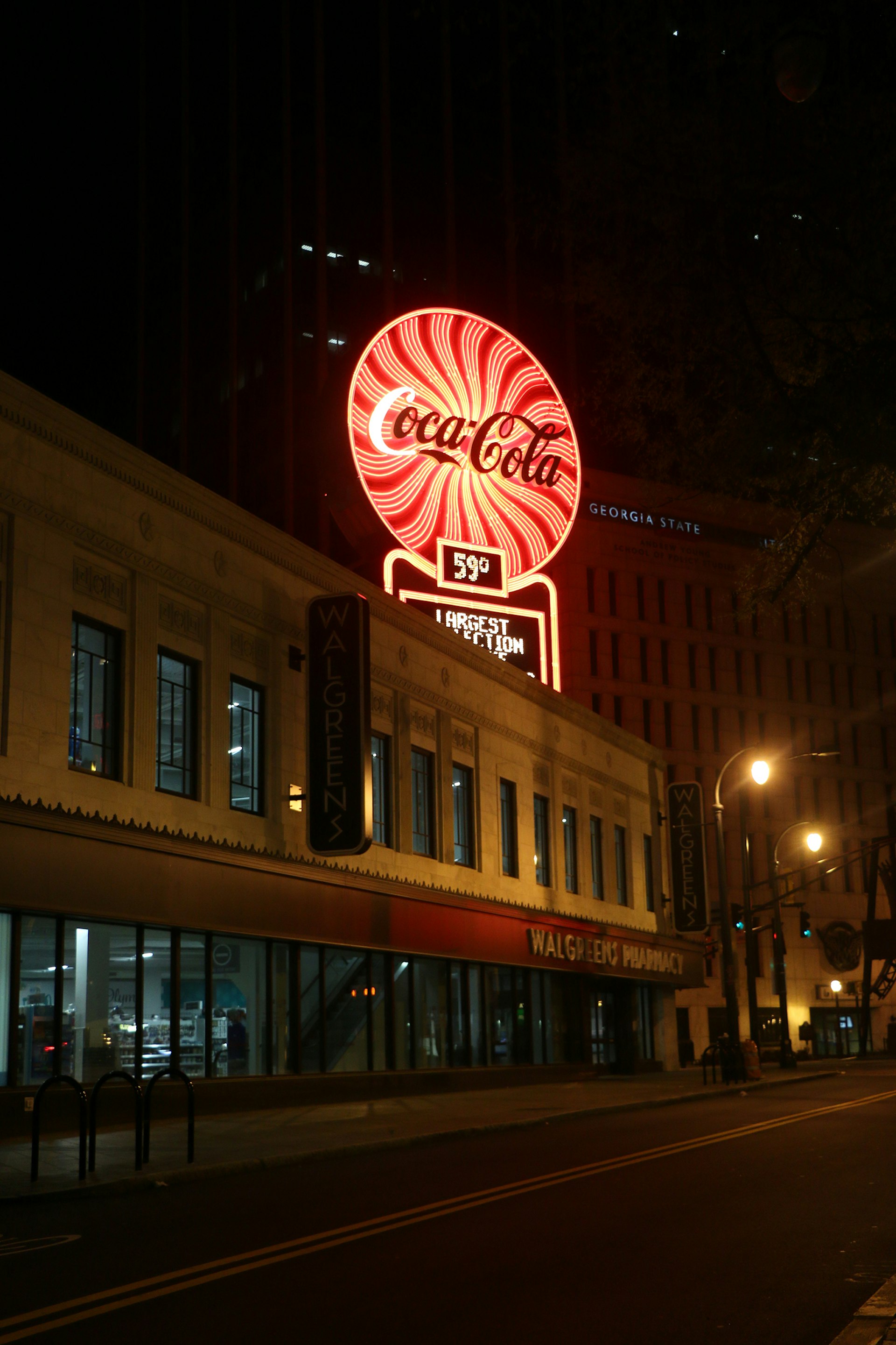 Neon red and white coca-cola emblem above a building at night © Ni'Kesia Pannell / Lonely Planet