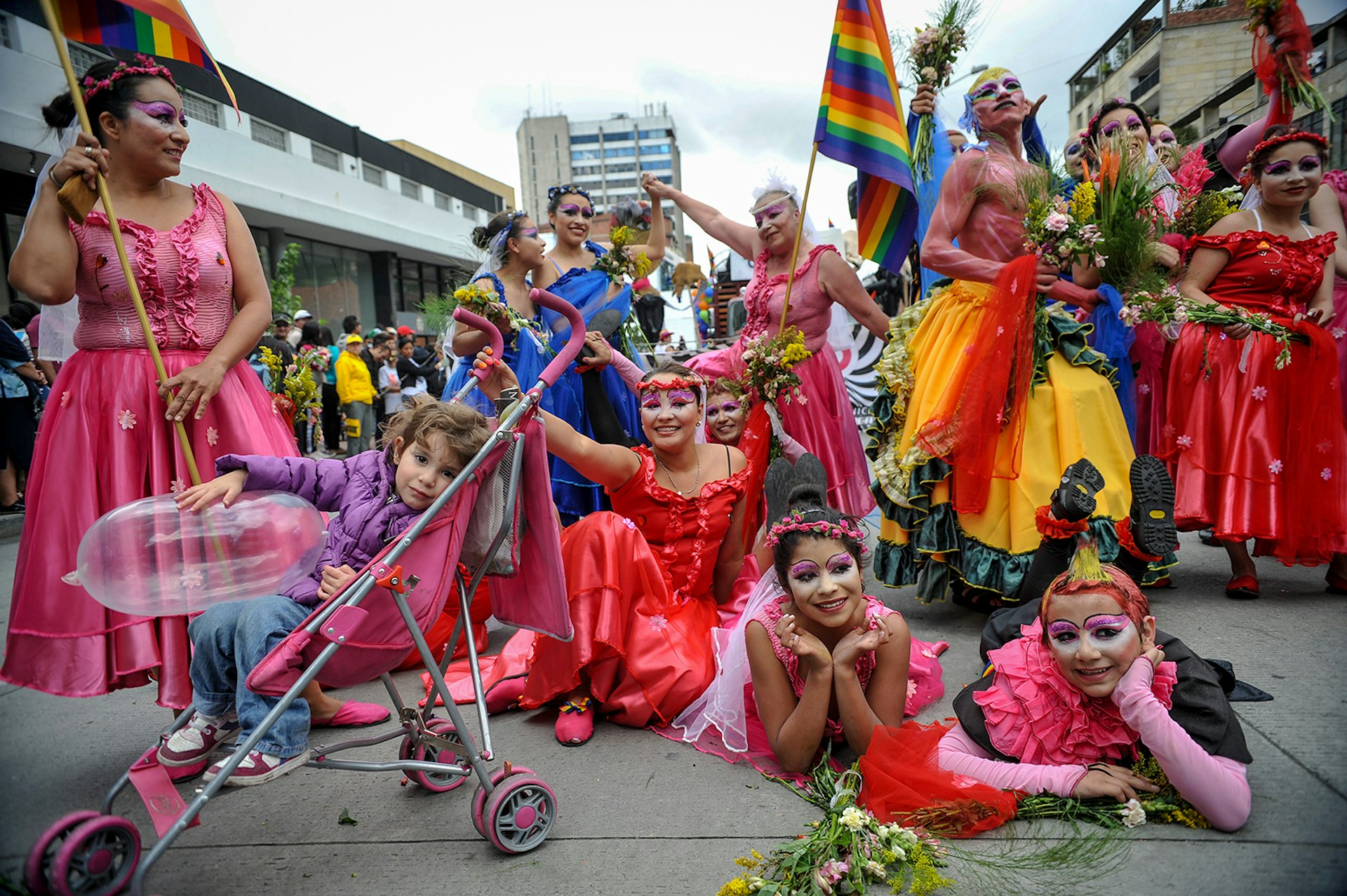 A group of people dressed in pink and red dresses hold Pride flags in Bogotá © GUILLERMO LEGARIA / GettyImages