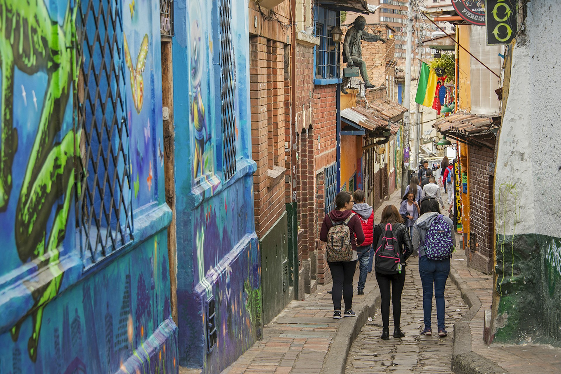 Women walk down an historic alley lined with street art© Krzysztof Dydynski / Getty Images