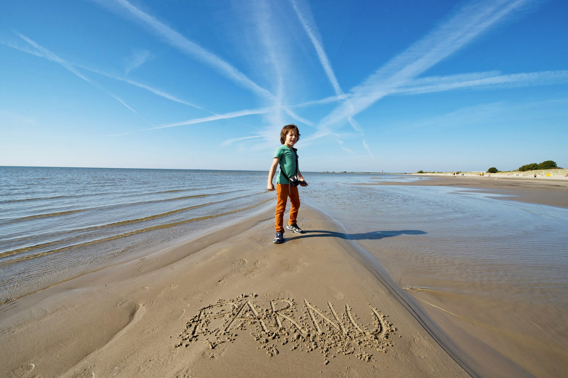 A child smiles on Pärnu beach on a sunny day © Paul Biris / Getty Images