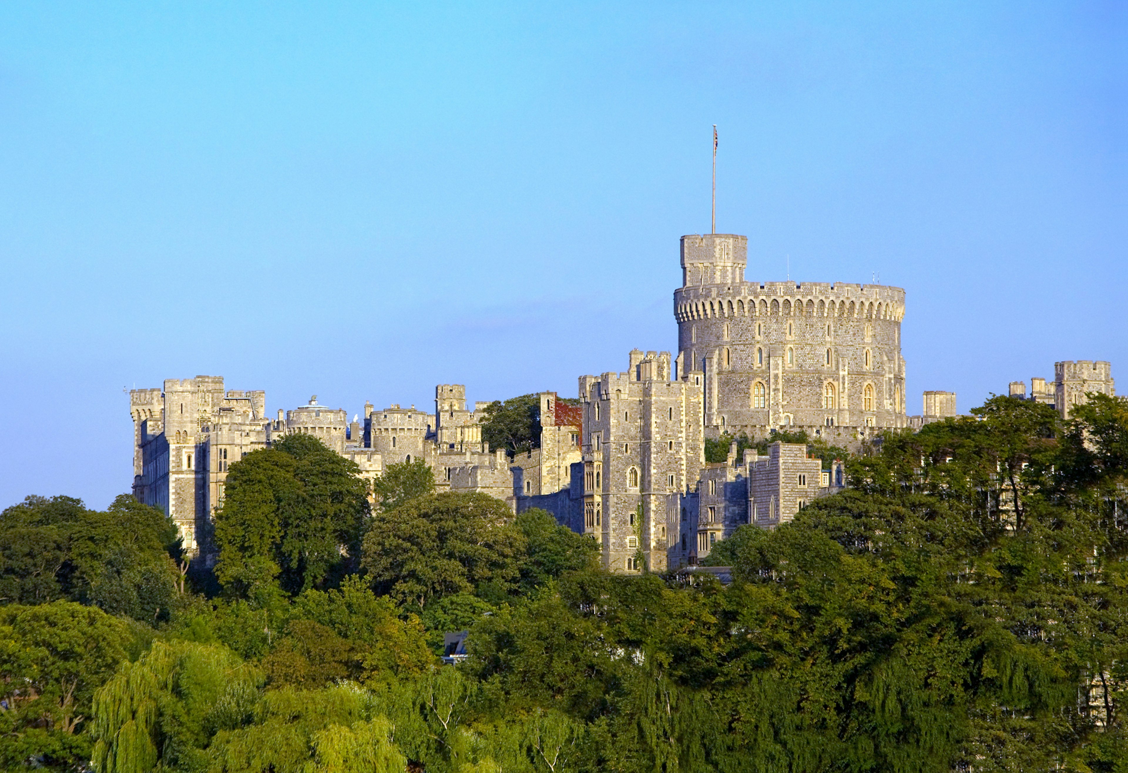 Windsor Castle's grand turrets tower above the surrounding trees © Scott E Barbour / Getty Images