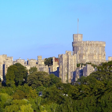 Windsor Castle's grand turrets tower above the surrounding trees © Scott E Barbour / Getty Images