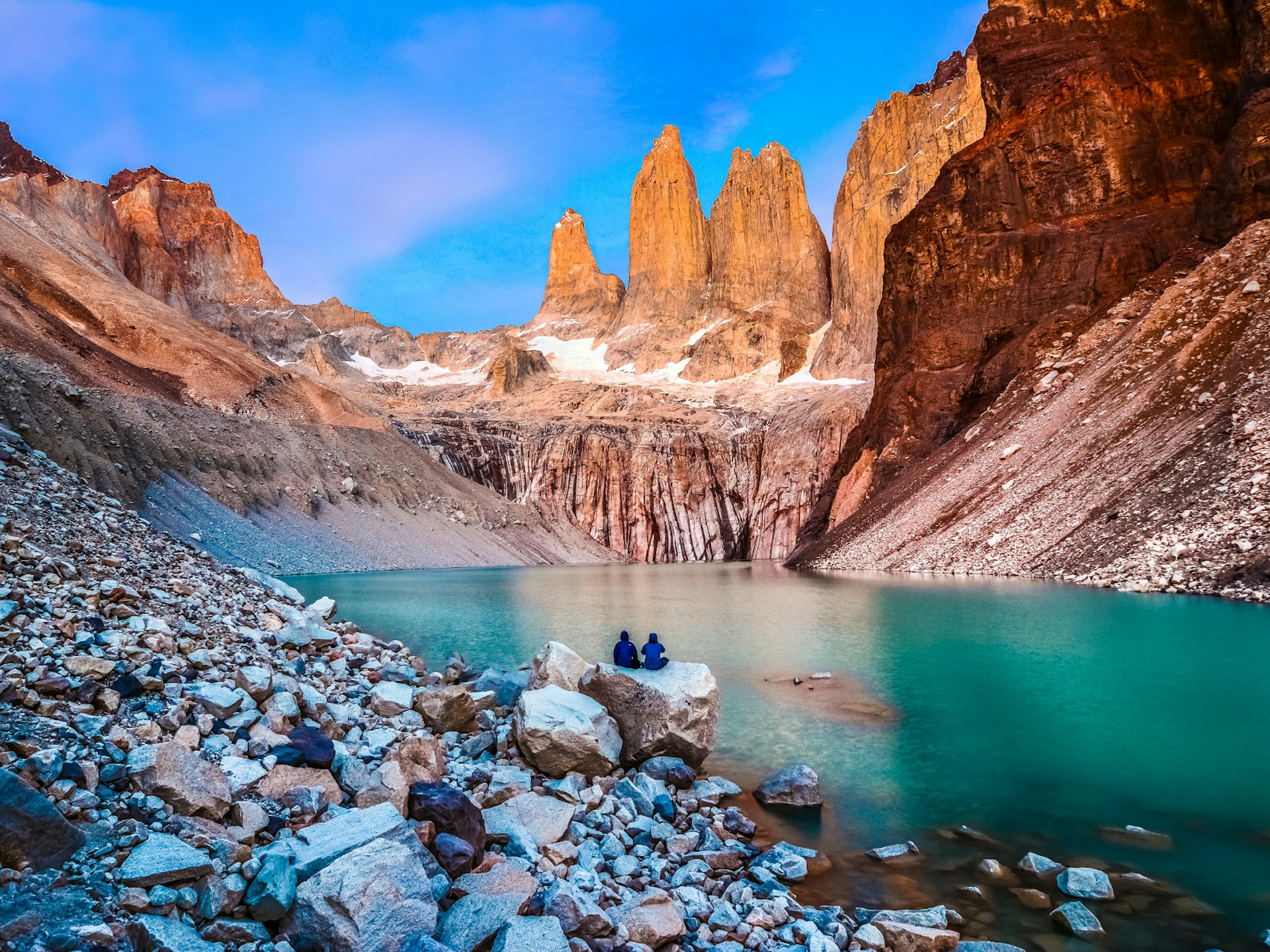 Two people sitting looking across Laguna Torres in the Torres del Paine National Park, Patagonia 