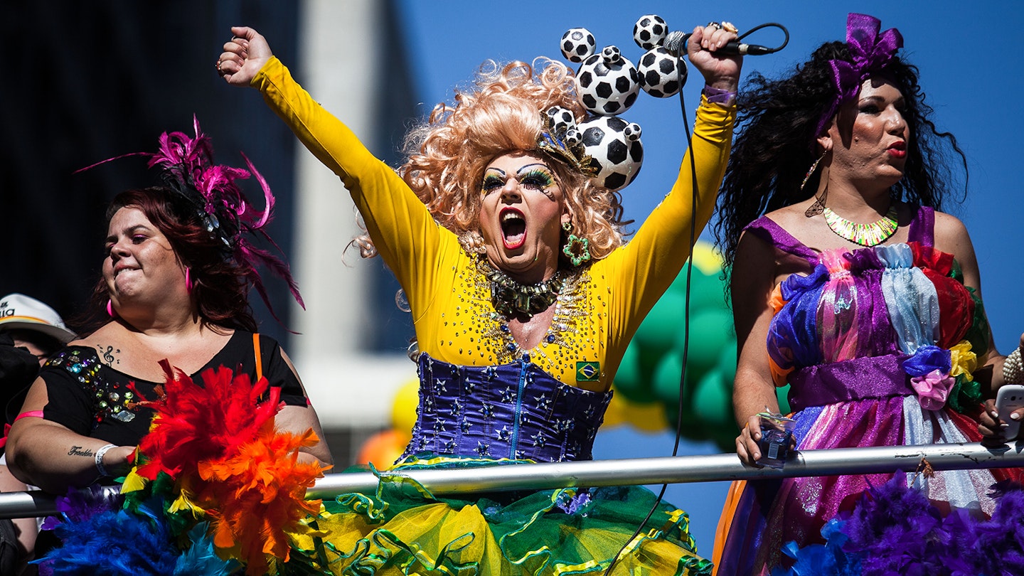 Three brightly clothed individuals celebrate Pride in Sao Paulo