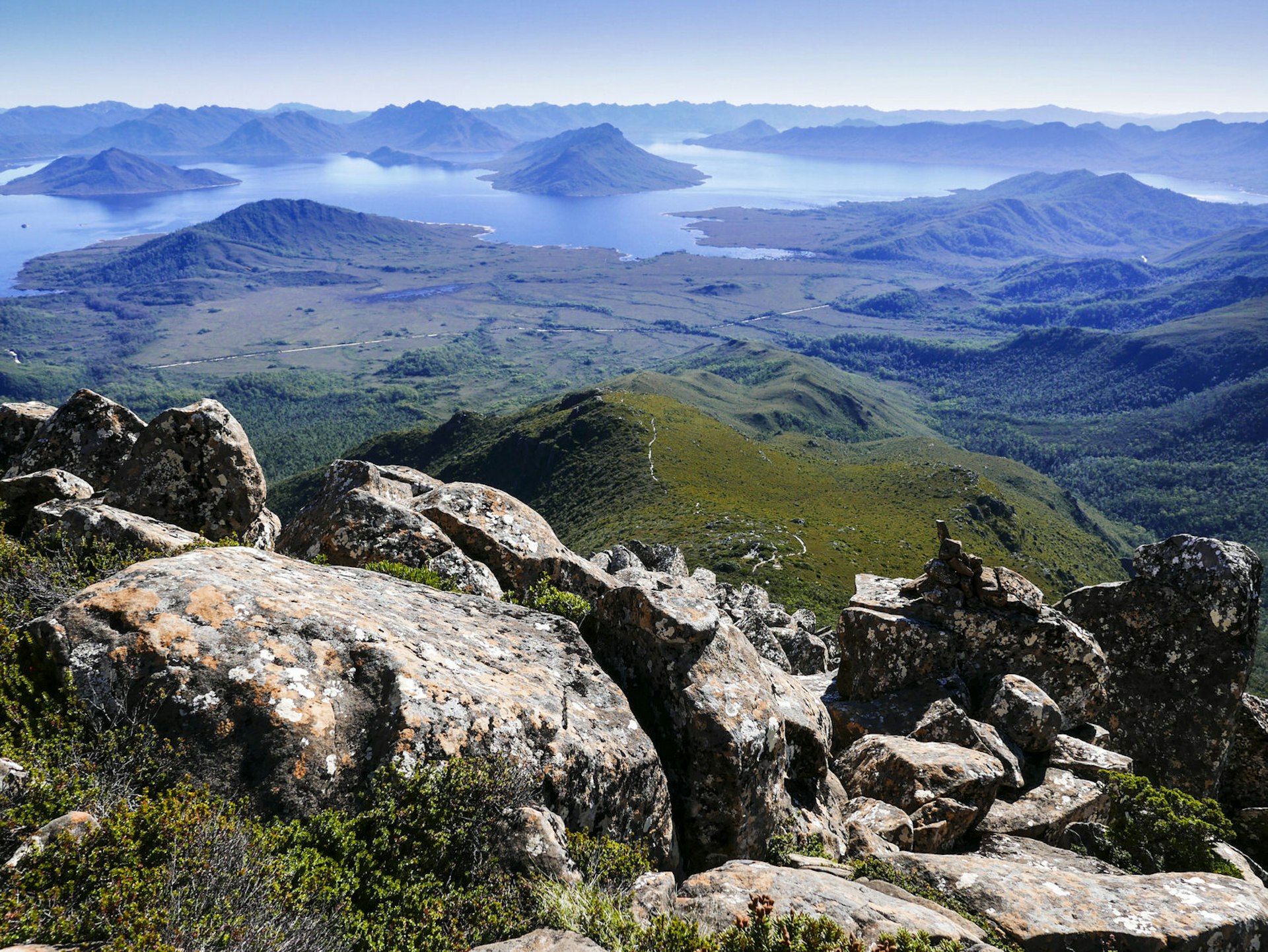 View of the surrounding countryside, including mountain peaks, boulders and a lake