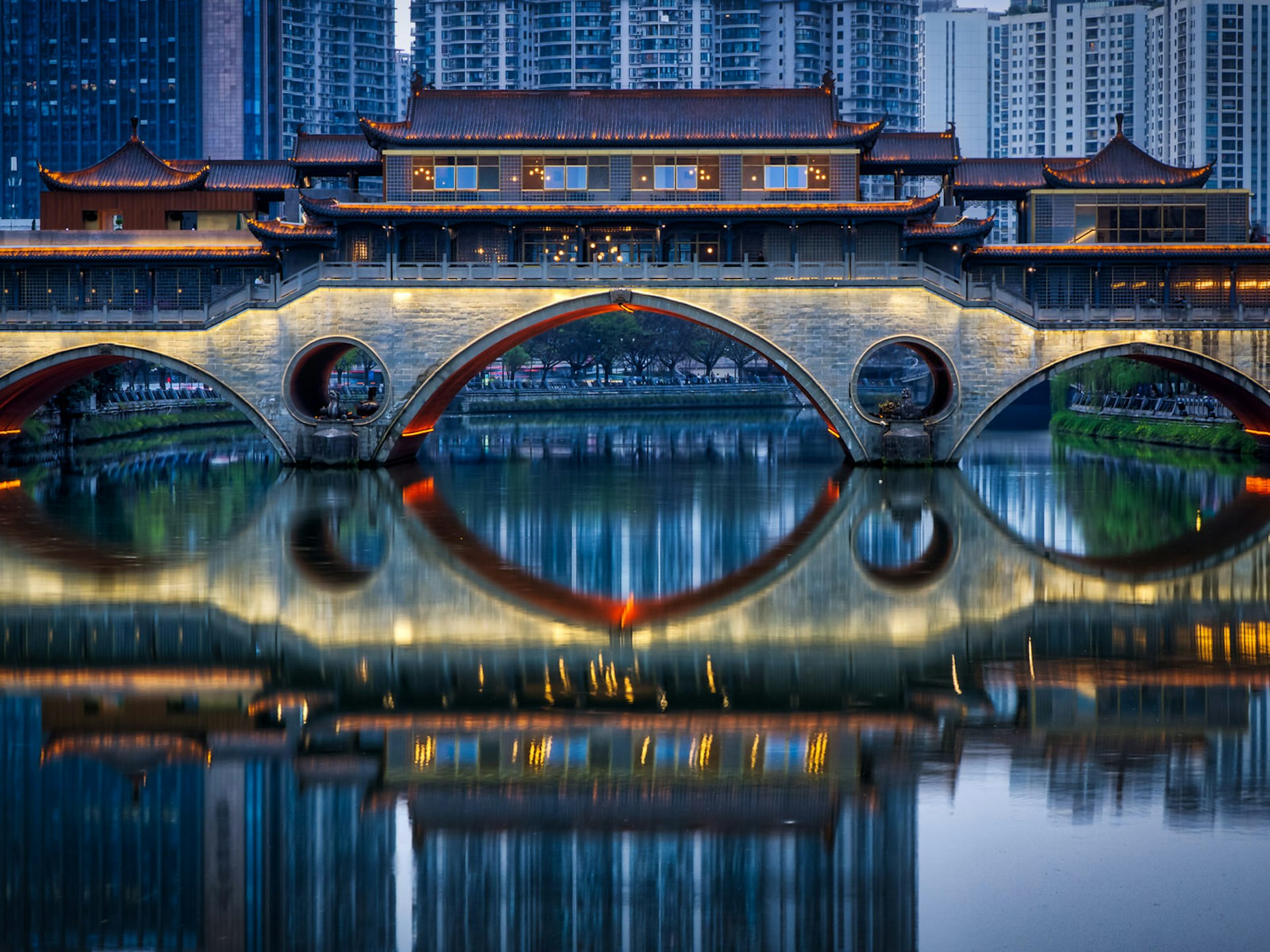 A covered Chinese bridge with modern buildings in the background. Chengdu's Anshun Bridge was mentioned by Marco Polo in his 13th century writings about China © Nick Wonnell / Shutterstock
