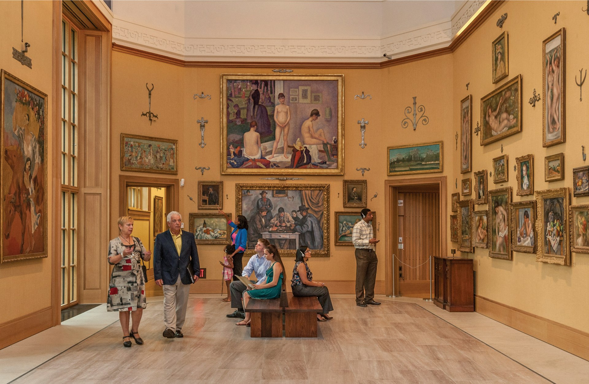 handful of museum patrons mill around a large, high-ceilinged room with late 19th-century masterworks on the walls