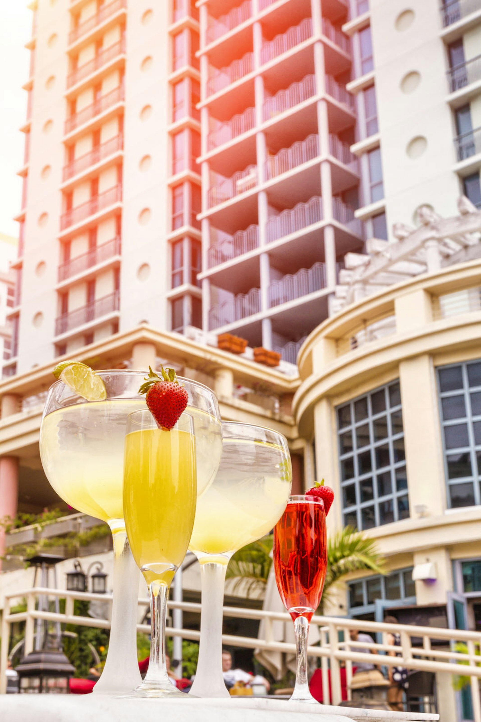 Cocktails are ready to drink by the waterfront, with a luxury South Beach condo in background © PJPhoto69 / Getty Images