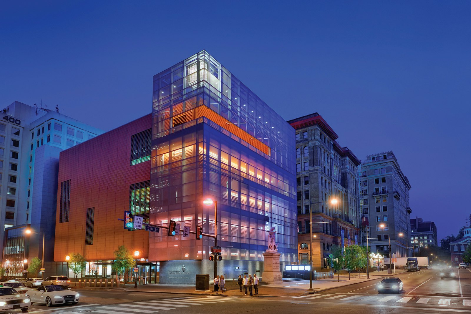 the glass facade of the National Museum of Jewish American History in Philadelphia, lit up in purples and blues at dusk © G. Widman for GPTMC