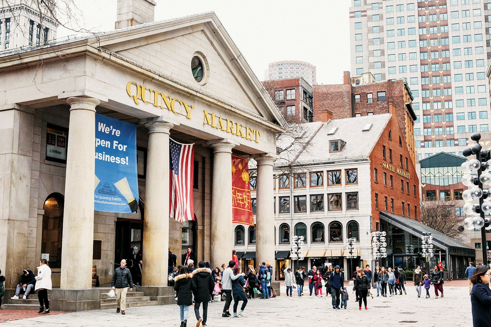 wide exterior shot of Quincy Market, a Greek Revival building in Boston with four columns © Adam DeTour / Lonely Planet 