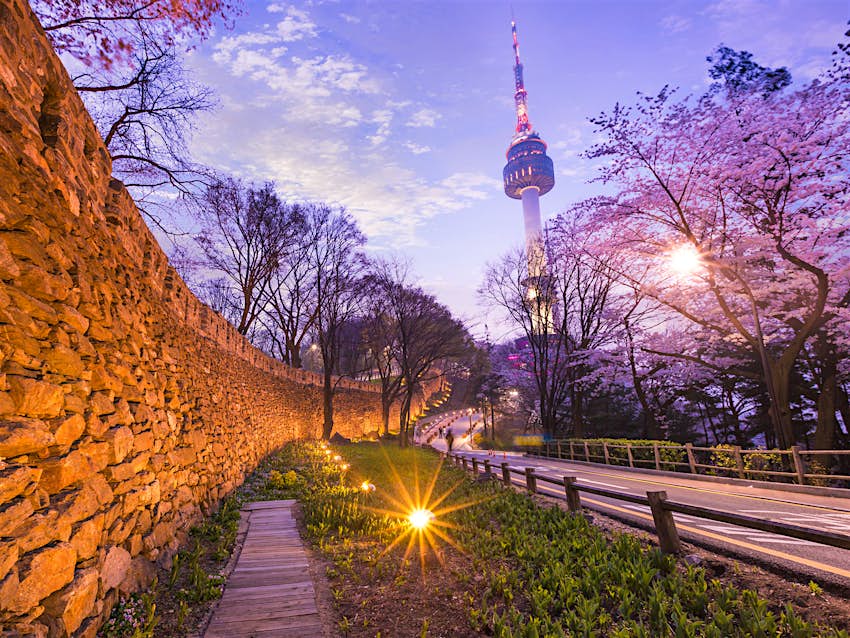 Features - Seoul City Wall is a great place for a free (and romantic!) evening stroll © PKphotograph / Shutterstock Seoul City Wall illuminated by night with purple sky and the N Seoul Tower in the background. Seoul City Wall is a great place for a free (and romantic!) evening stroll © PKphotograph / Shutterstock
