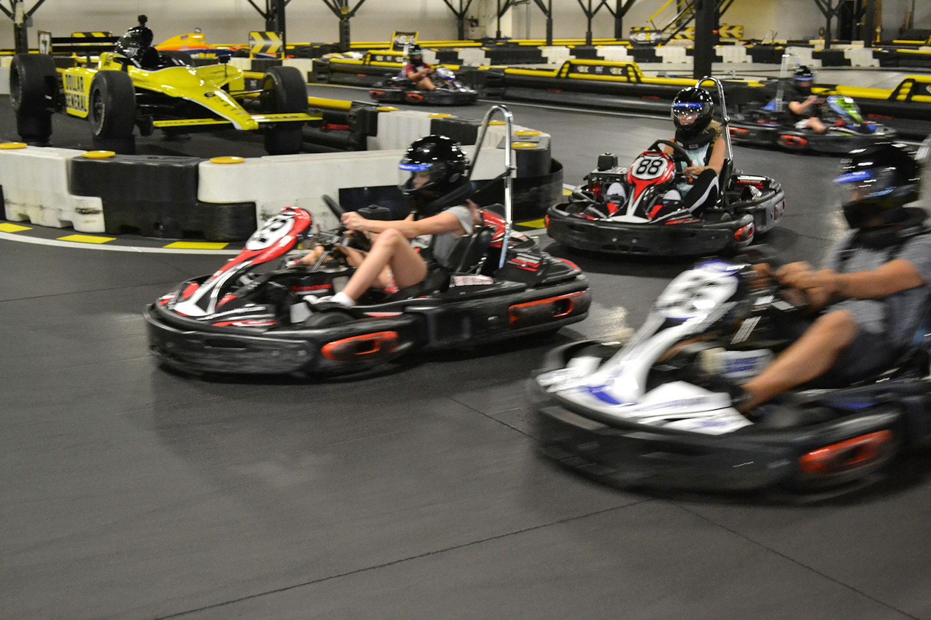two women and a man race go-karts on an indoor track in Indianapolis © SIK