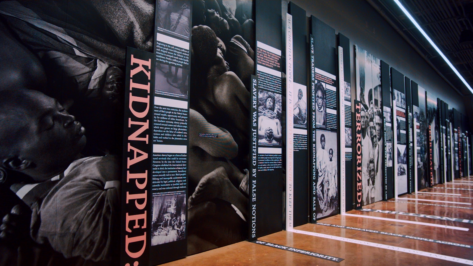 A graphic timeline of the evolution of slavery and racism in the United States, including text and images, lines a wall of the Legacy Museum in Montgomery, Alabama © Equal Justice Initiative / Human Pictures