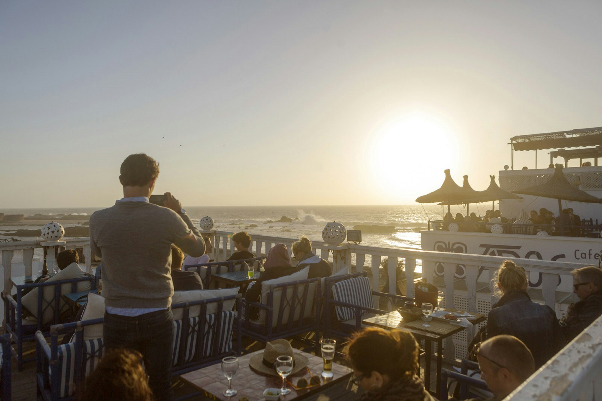 Diner taking a photo on top of Taros, Essaouira, Morocco © Chris Griffiths / Lonely Planet
