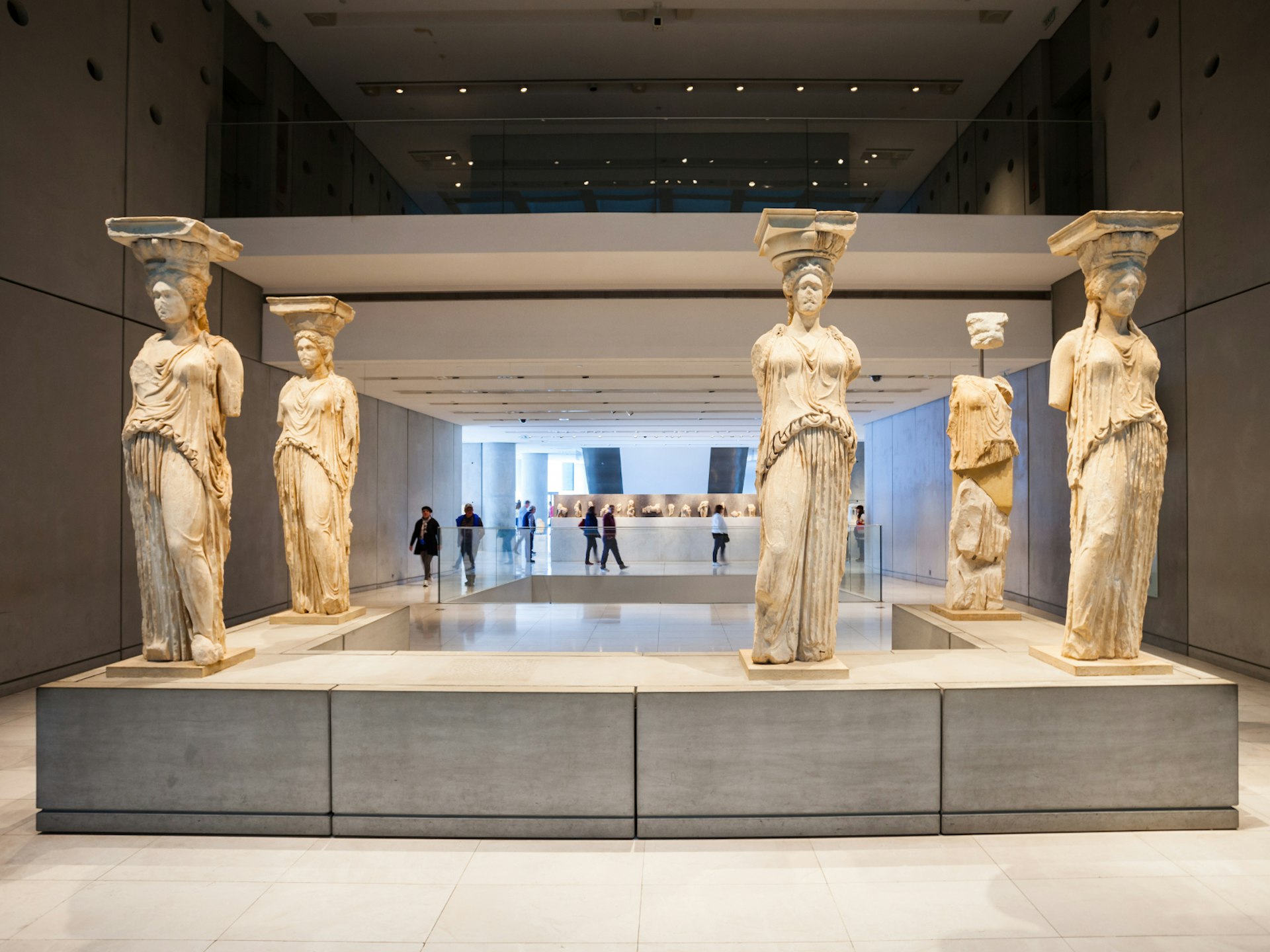 Five armless (and one headless) marble statues stand on a u-shaped plinth