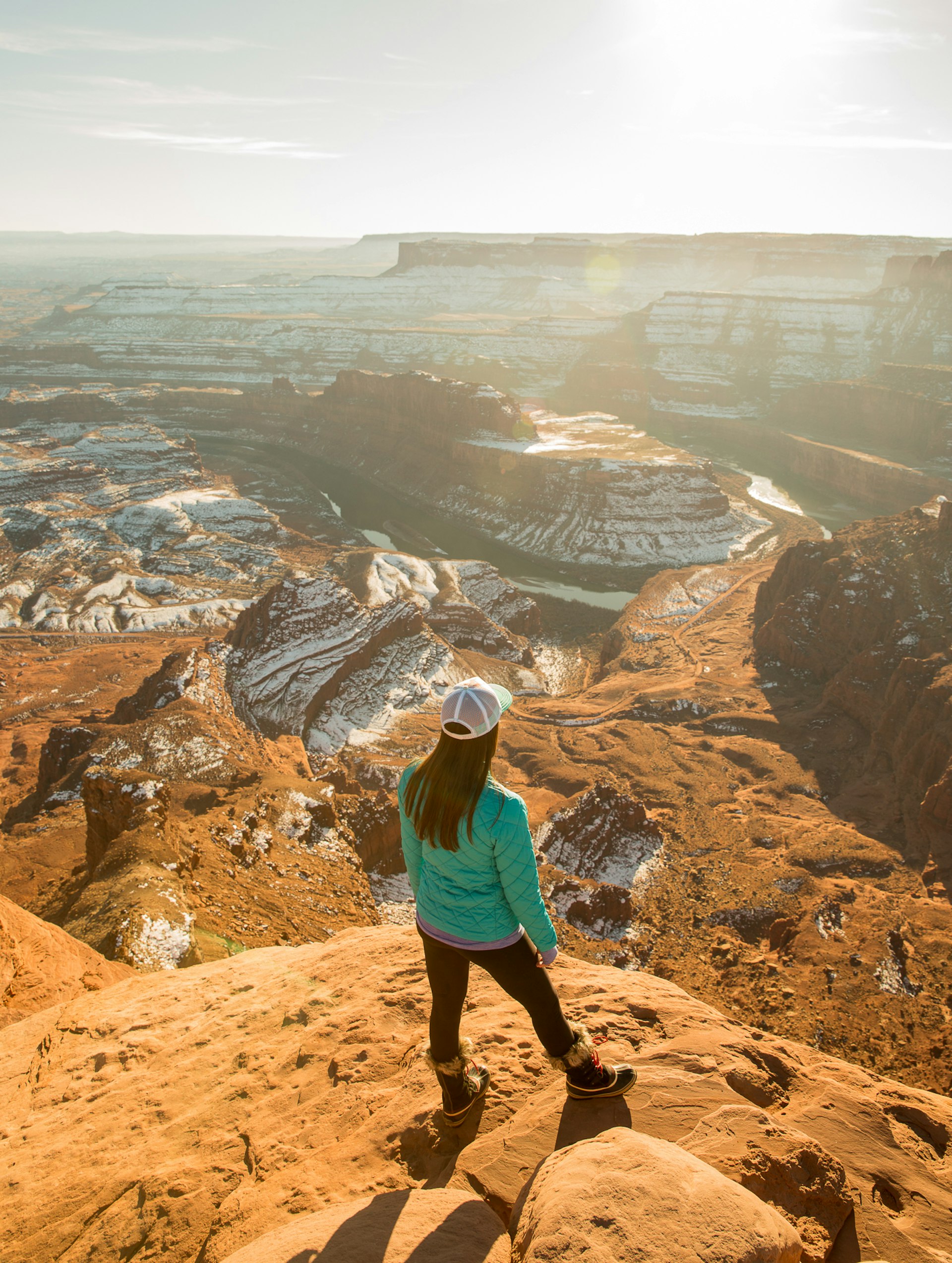 Woman admires the view of deep canyons dusted with snow in South Eastern Utah © Gabriel Rovick / Lonely Planet