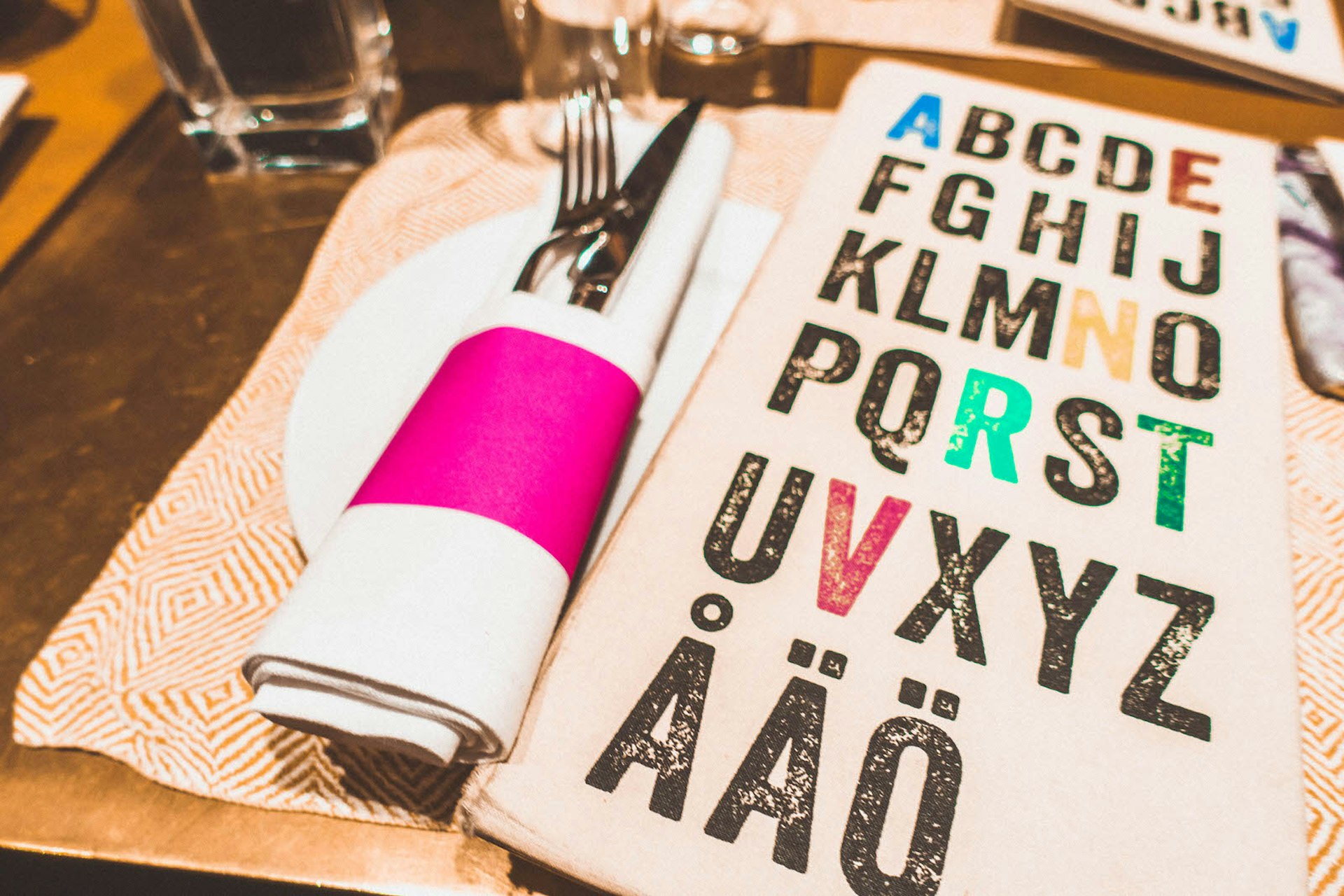 The colourful place settings at Taverna Brillo restaurant with a white and pink napkin and a stylish menu © Megan & Whitney Bacon-Evans / Lonely Planet