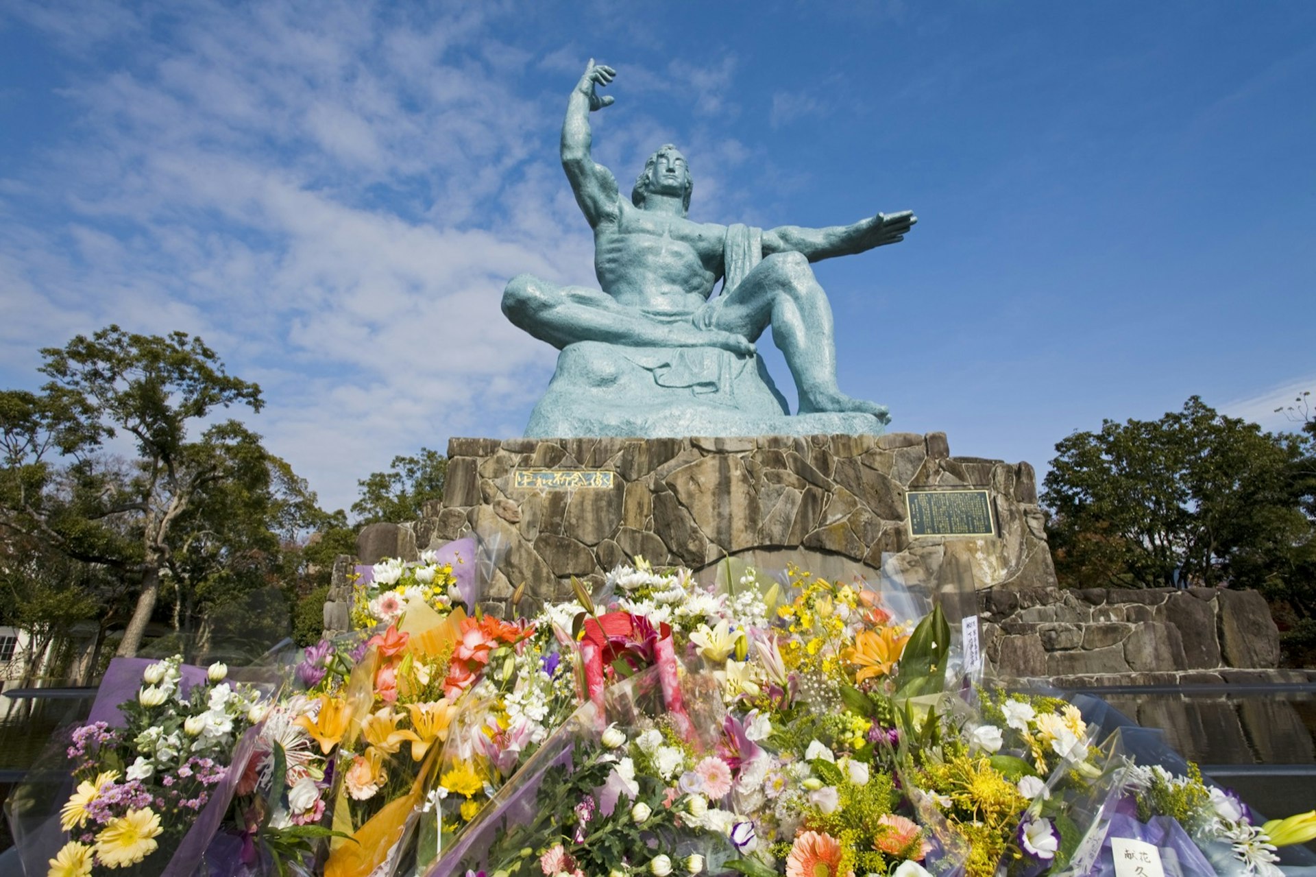 A massive statue of a man pointing to the sky is surrounded by flowers © Richard Cummins / Getty Images