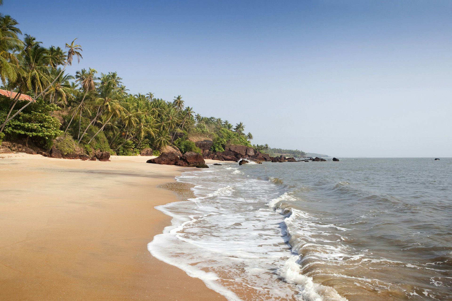 A golden sandy beach with small breaking waves in northern Kerala © Neil Mcallister / Getty Images