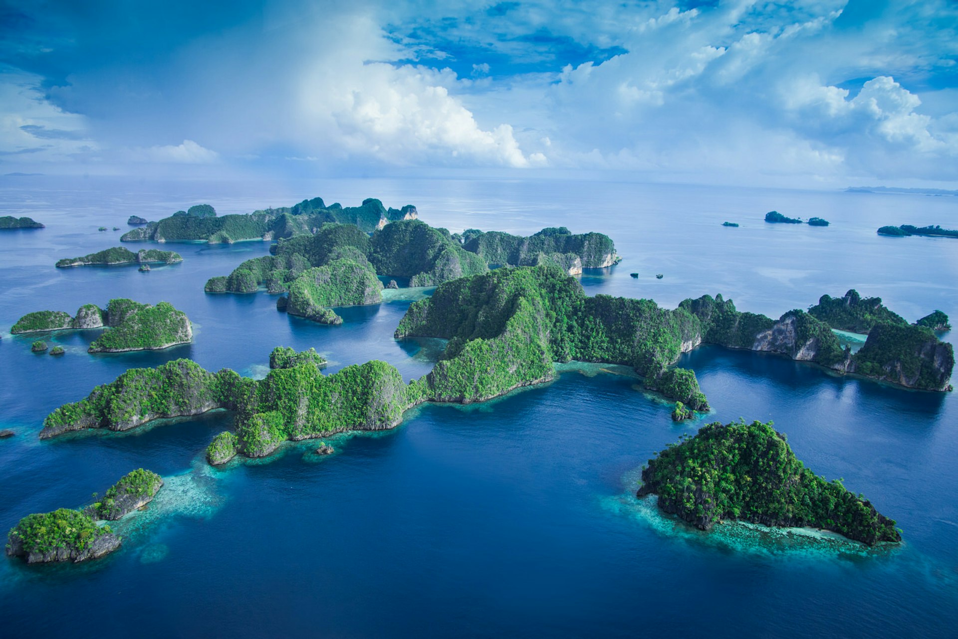 A number of lush green islands protrude from turquoise waters © Jones/Shimlock-Secret Sea Visions / Getty Images
