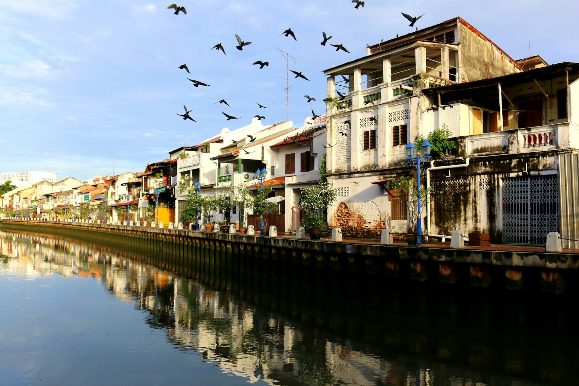 Restaurants and cafes lining the banks of the Melaka River are reflected in the river's still waters © Frans Sellies / Getty Images