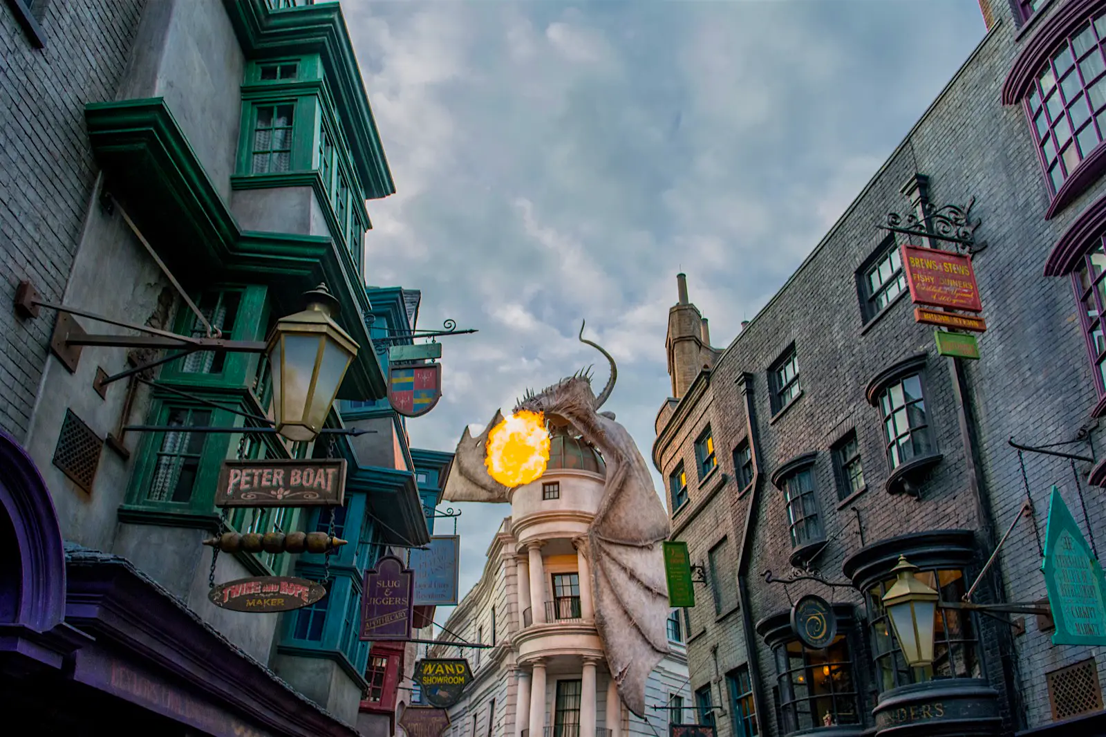 Features - The Wizarding World of Harry Potter - Diagon Alley An animatronic dragon shoots fire out of its mouth on top of a building; north america's top amusement parks