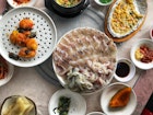 Platters of fish and small bowls of Korean food on a table. Thanks to its oceanside location, Busan's culinary scene is anchored on seafood © MaSovaida Morgan / Lonely Planet