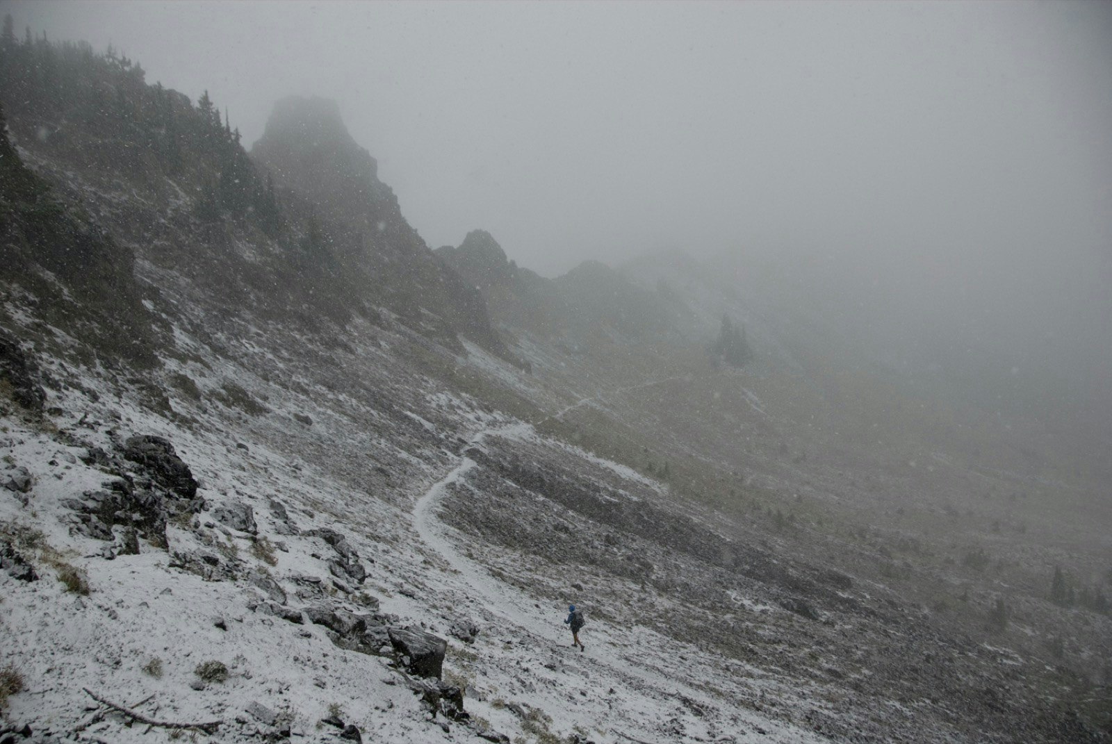 Snow dusts a lonely portion of the trail as a solitary hiker makes his way through a mountain pass shrouded in fog on the Pacific Crest Trail © Sean Jansen / Lonely Planet 