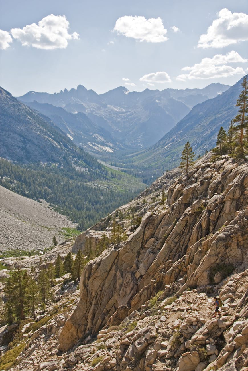 Klippiga berg dominerar förgrunden när topparna i Sierra Nevada-området sträcker sig långt in i bakgrunden på Pacific Crest Trail © Sean Jansen / Lonely Planet