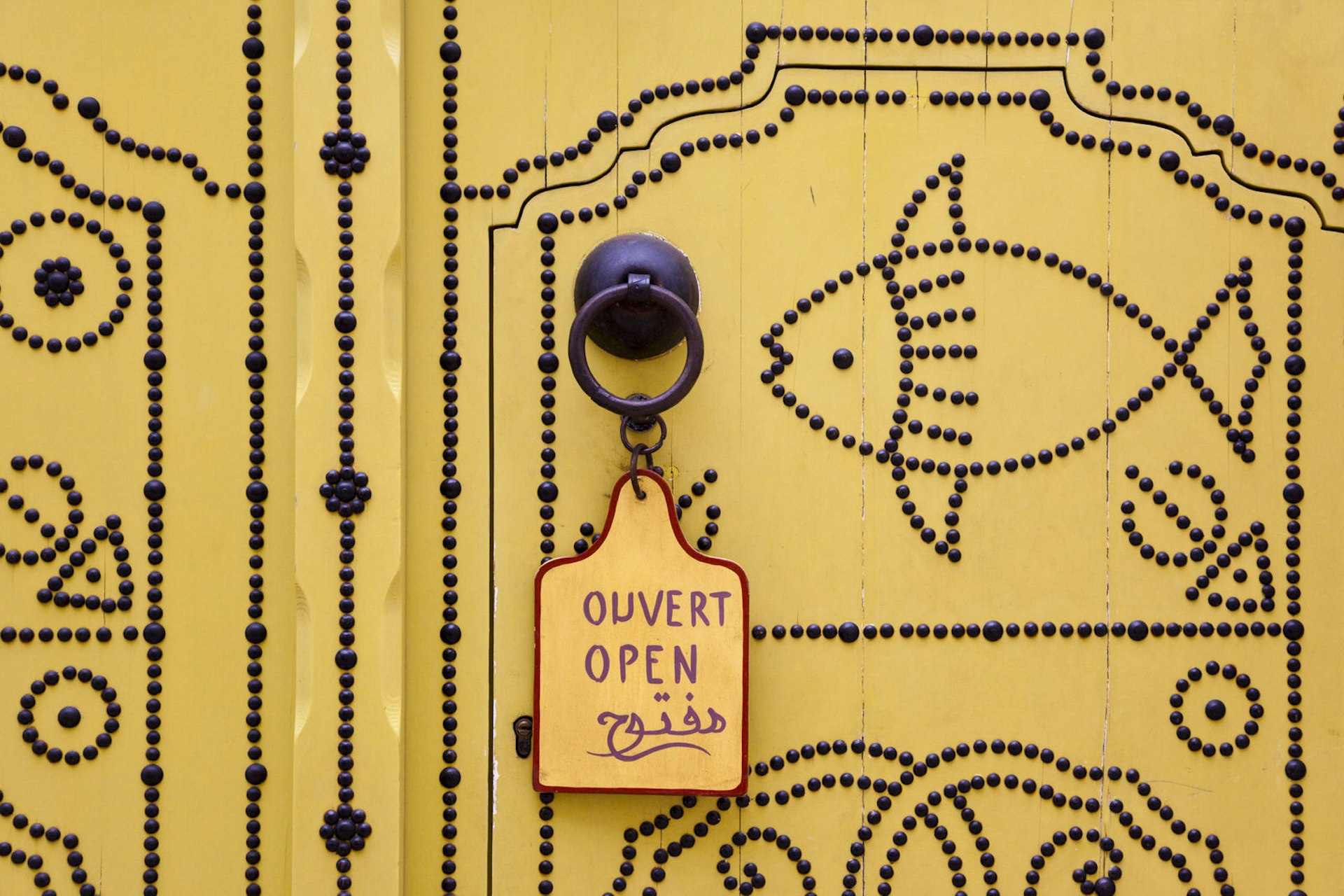 Tunisian door with an 'open' sign on it © Walter Bibikow / Getty Images