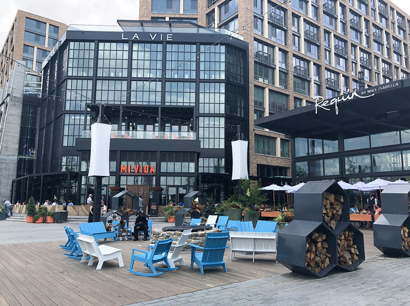 Blue and white adirondack chairs cluster around a firepit on the District Wharf © Trisha Ping / Lonely Planet