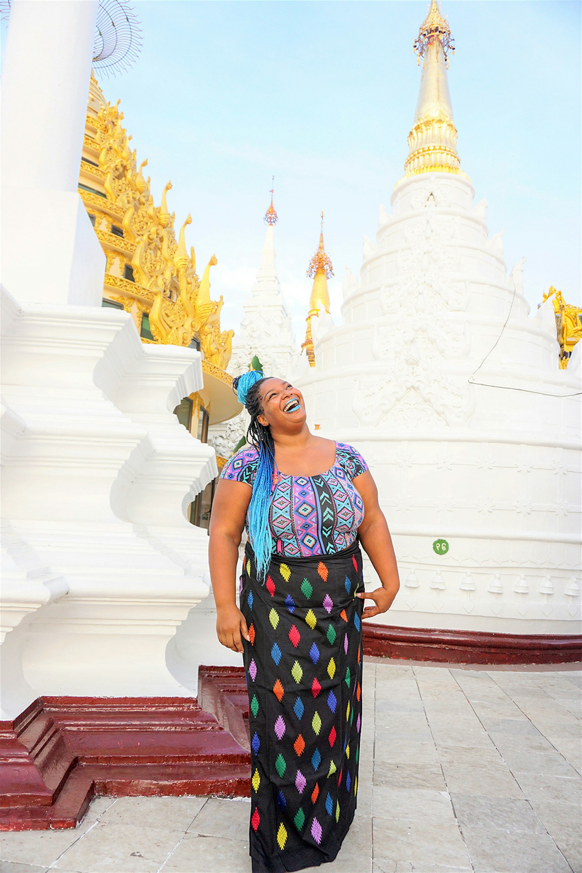 A woman stands in front of white temple spires in Myanmar © Annette Richmond