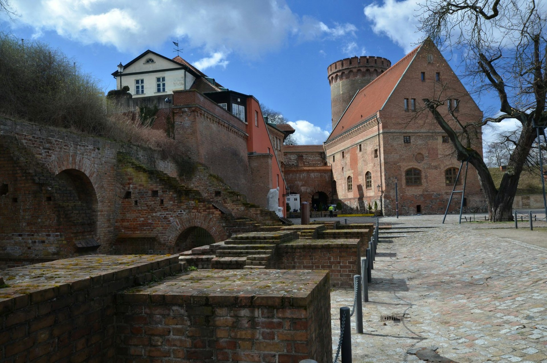 Berlin day trips - an image from inside the Spandau Citadel. The Renaissance military fortress has a cobbled courtyard and red-brick buildings
