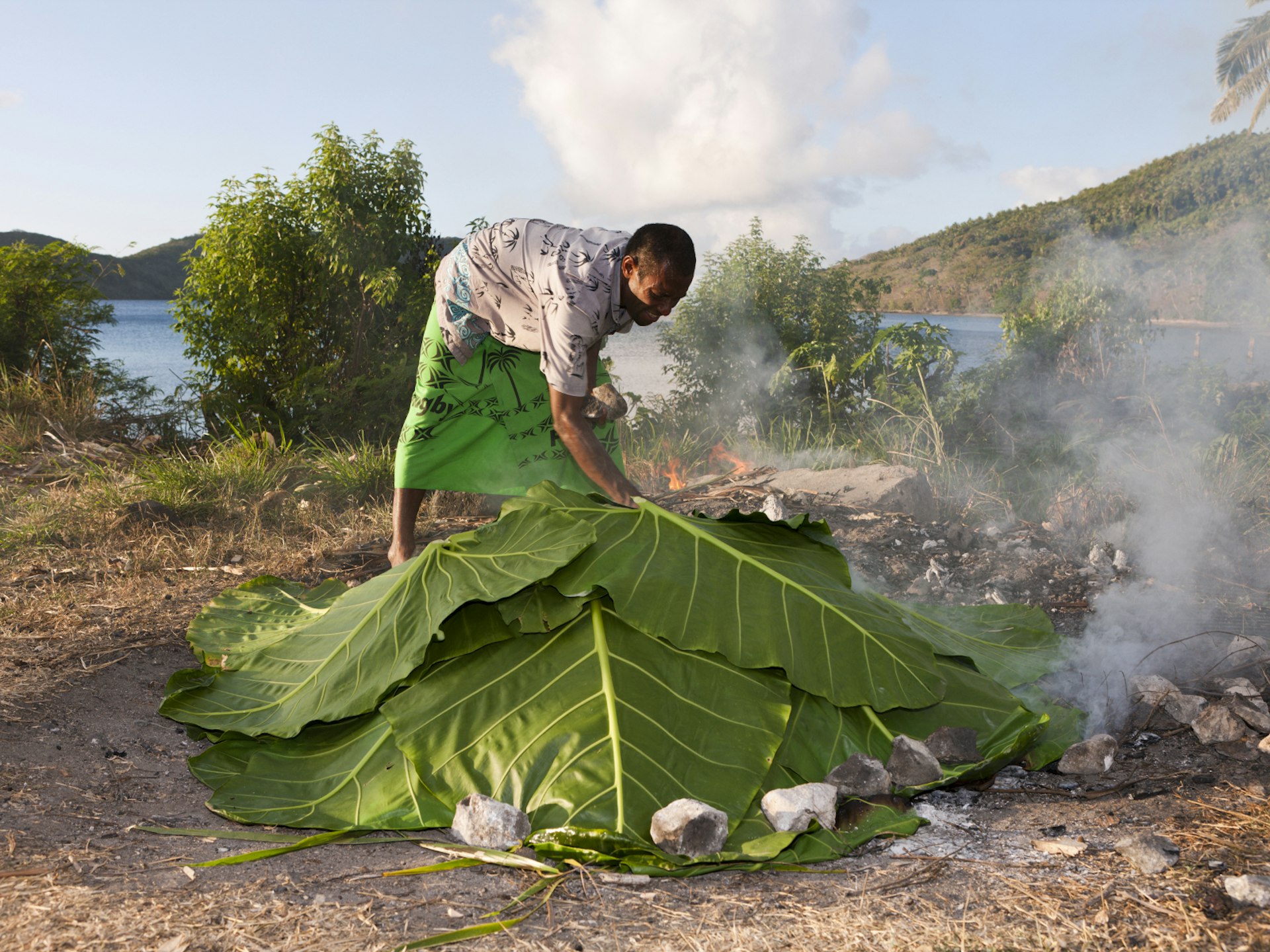 A Fijian native cooks up a feast using a lovo-style oven © ullstein bild / Getty Images
