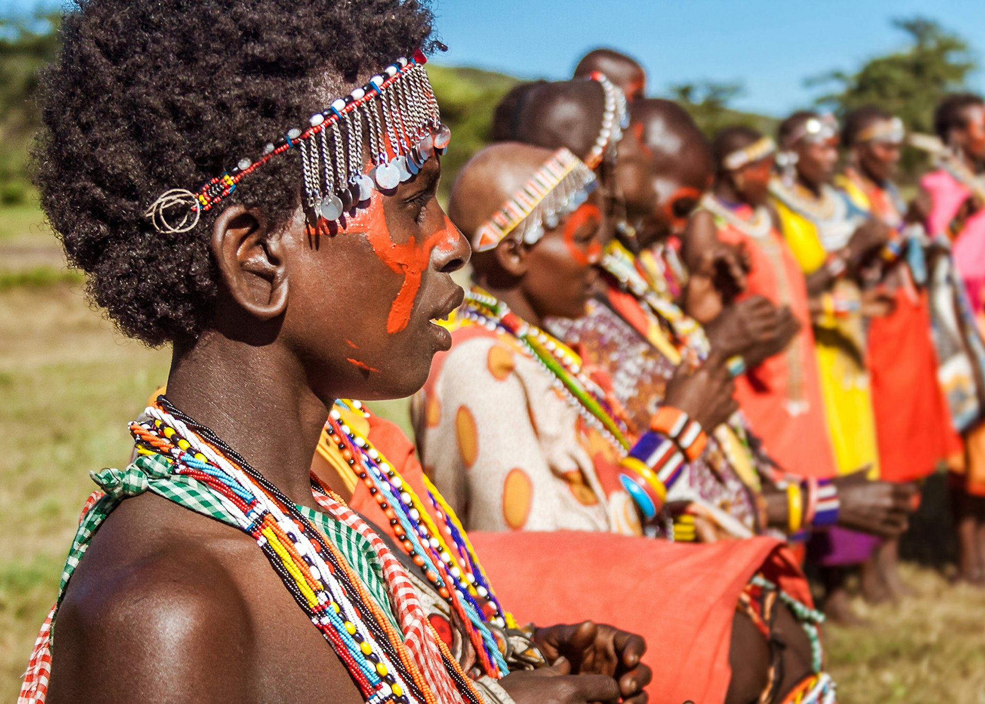 Masai women in traditional costume lined up during a ceremony © pierivb / Getty Images