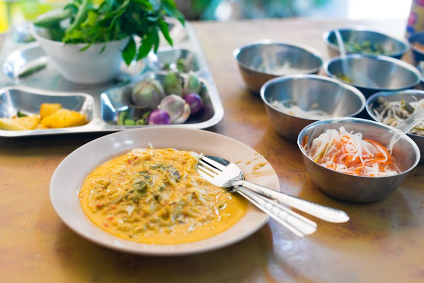 Khanom jeen, en sorts kryddig skaldjurscurry, är en typisk, älskad frukosttallrik i Phuket © Austin Bush / Lonely Planet