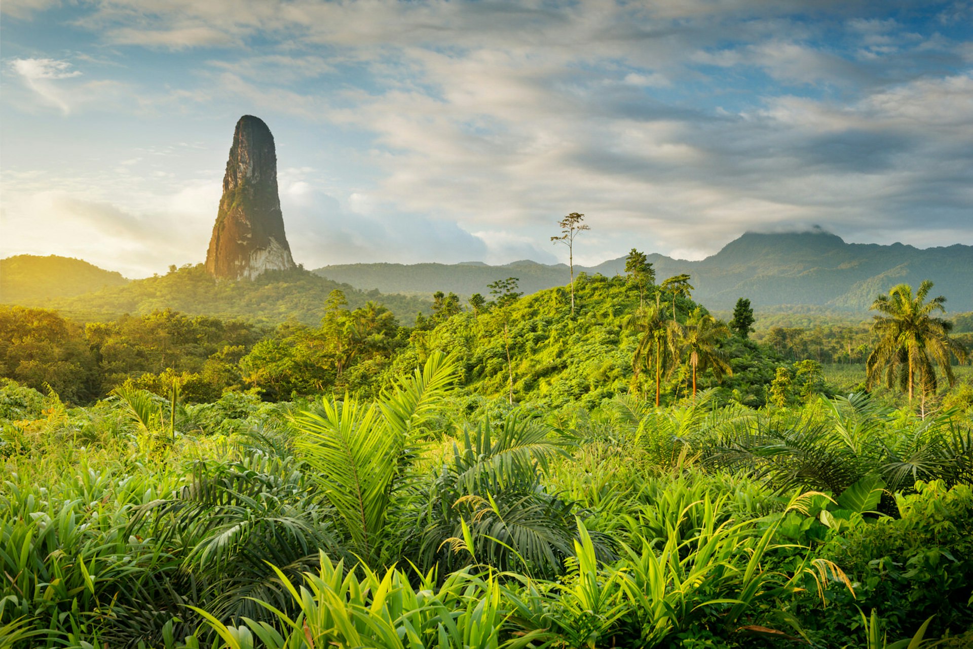 A massive rock tower, resembling an index finger bursts out of the jungle and rises into the sky © Justin Foulkes / Lonely Planet