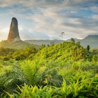 A massive rock tower, resembling an index finger bursts out of the jungle and rises into the sky © Justin Foulkes / Lonely Planet