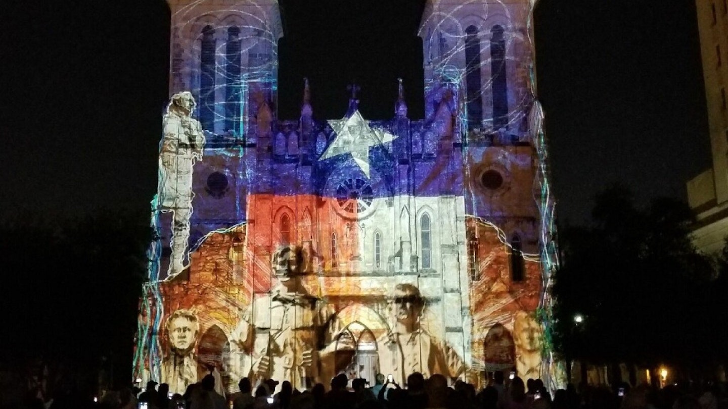 Scenes of San Antonio history, with the colors and star of the Texas flag, are projected on the front of a cathedral © Vicki Arkoff / Lonely Planet