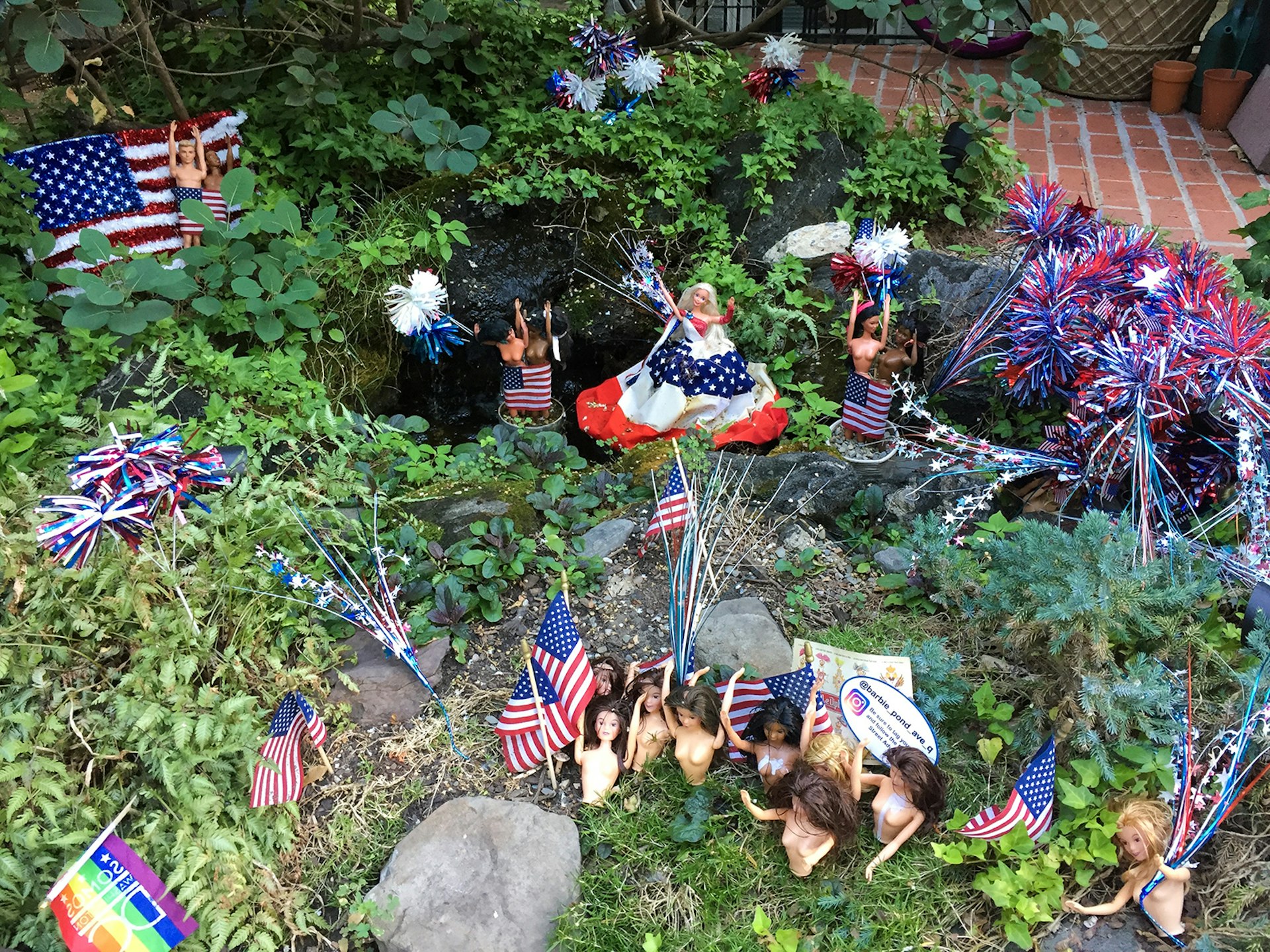 An assortment of Barbie dolls dressed for the Fourth of July holiday in red, white and blue, amid greenery around a small pond in a front yard in Washington DC © Barbara Noe Kennedy / Lonely Planet