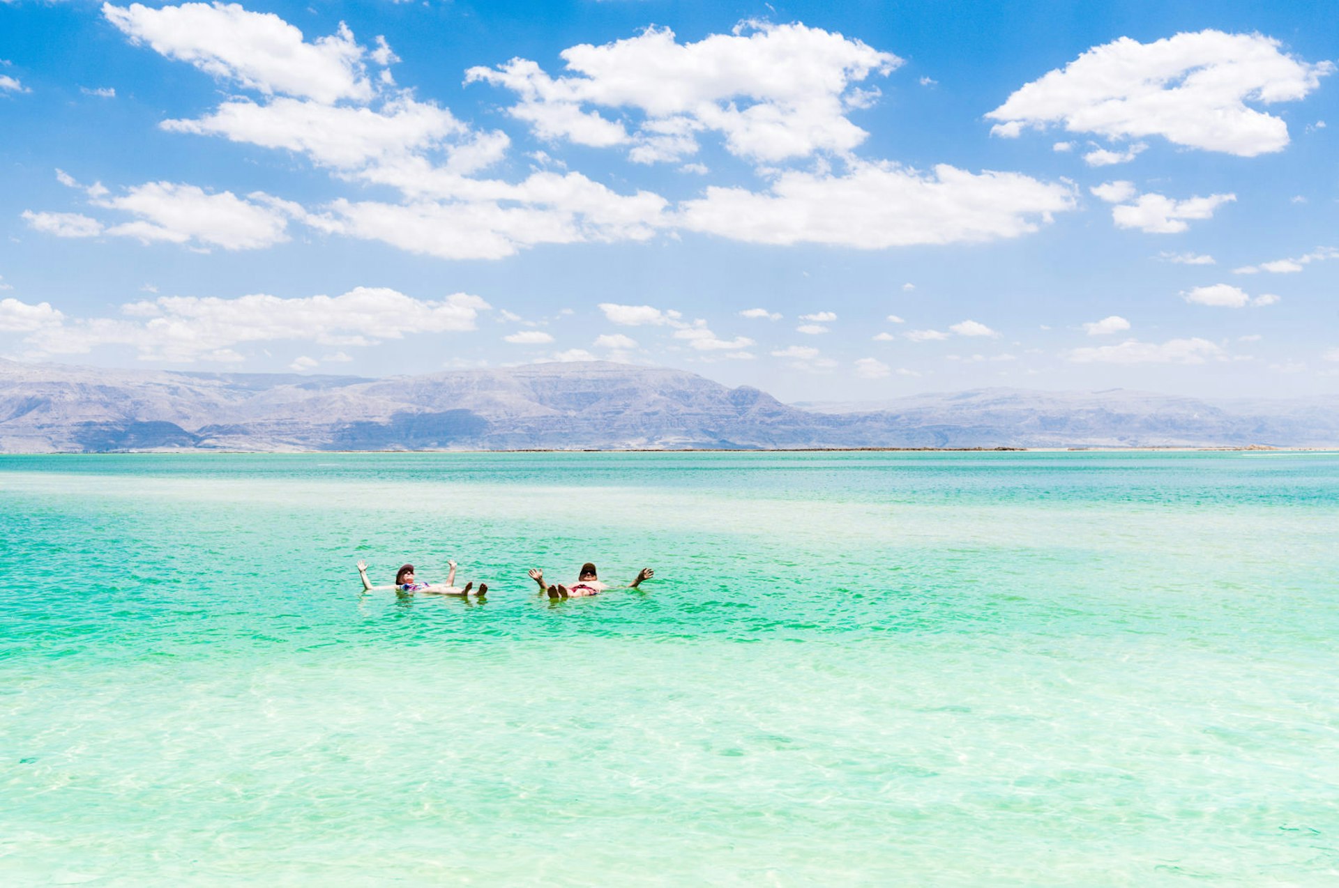 Couple relaxes in the water of the Dead Sea © Olesya Baron / Shutterstock