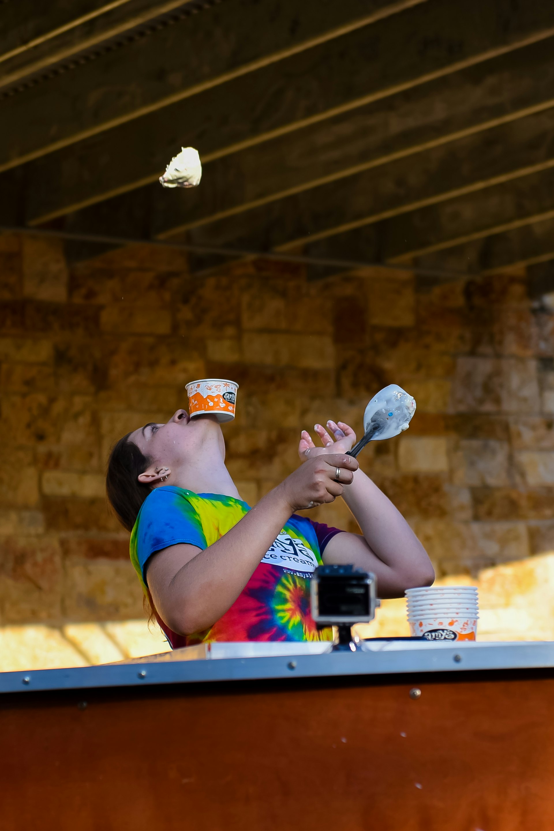 Woman flips ice cream into the air while balancing a cup on her chin © Amy's Ice Cream