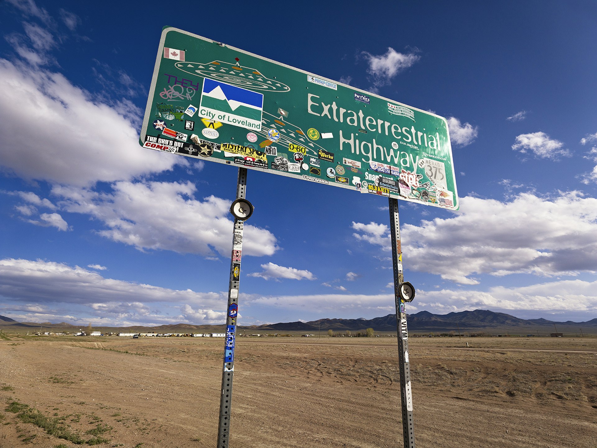 A highway sign covered in stickers advertises the Extraterrestrial Highway in the desert of Nevada © Siqui Sanchez / Getty Images