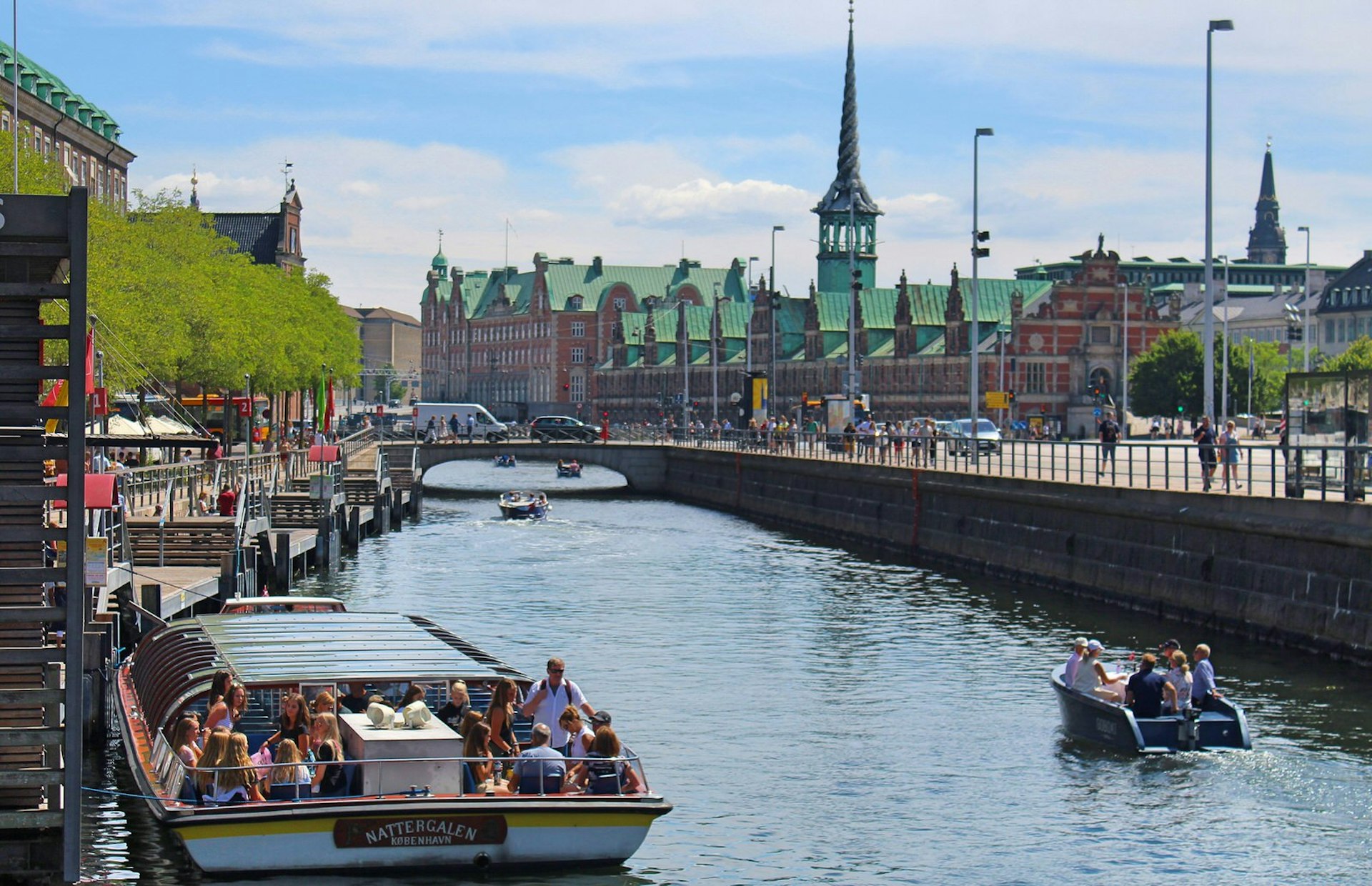 A view of a Copenhagen canals on a sunny day, with several pleasure boats filled with visitors © Caroline Hadamitzky / Lonely Planet
